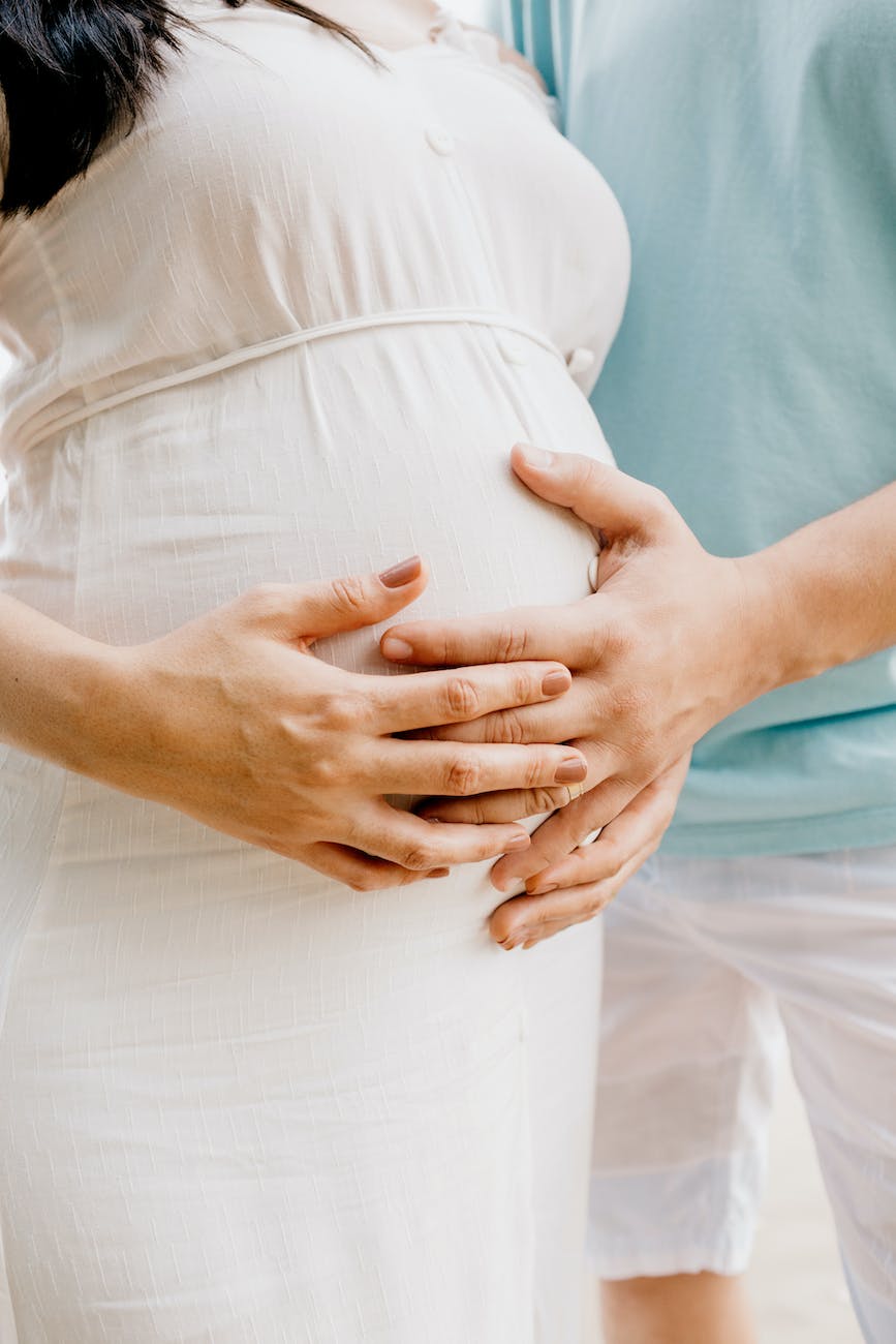 photo of hands touching baby bump