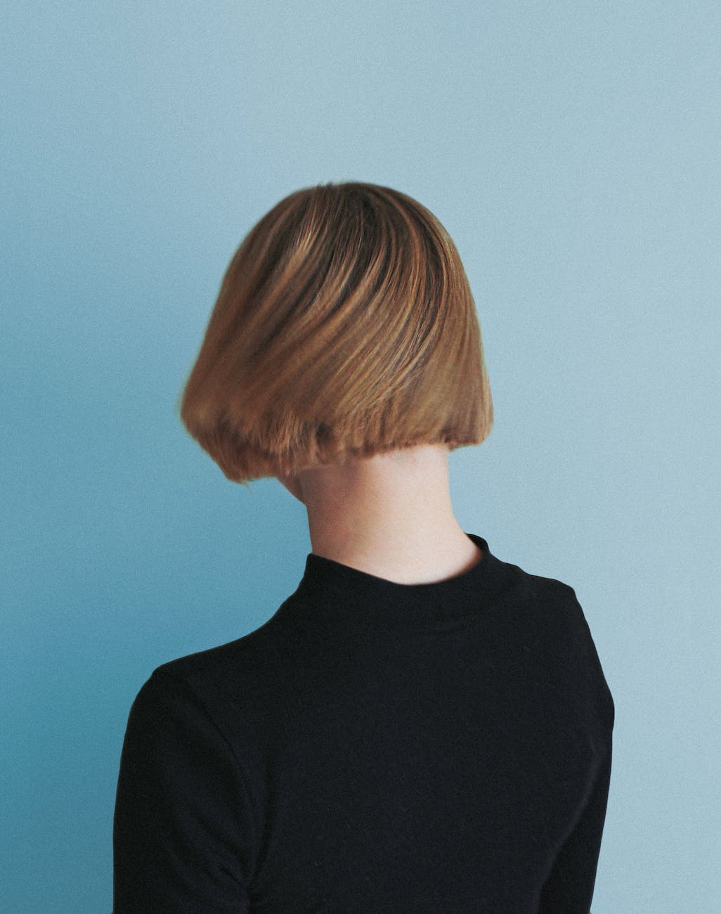 back view shot of a person with short hair wearing black shirt